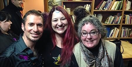 A man and two women are posing for a picture in a library, members of the Aquarian Tabernacle Church.