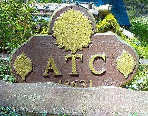 A wooden sign that says atc on it from the Aquarian Tabernacle Church.