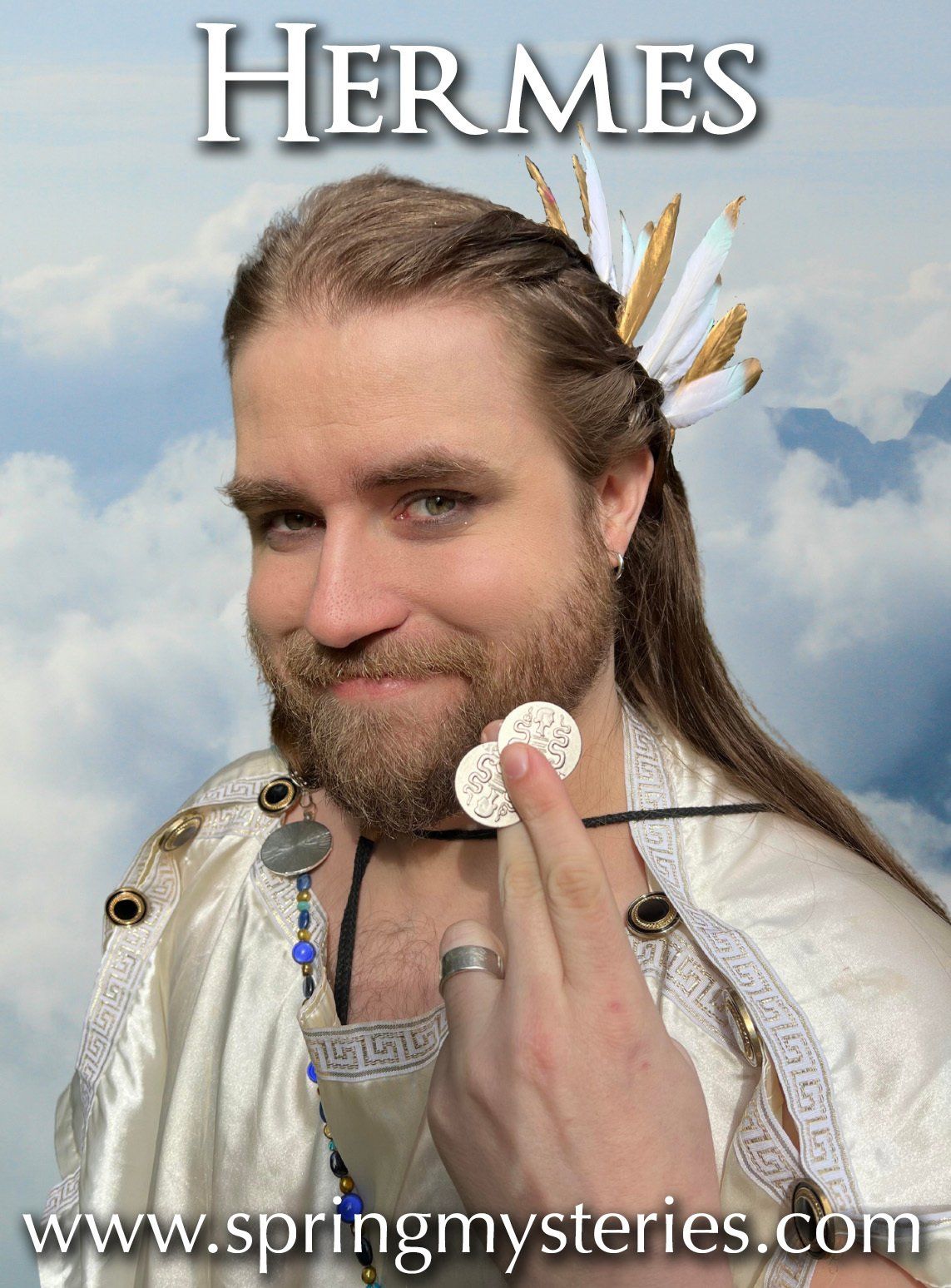 A man with long hair and a beard is wearing a Hermes costume, holding two coins