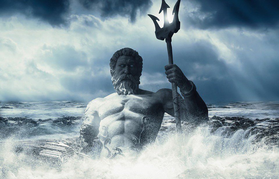 A statue of a Poseidon holding a trident in the ocean.