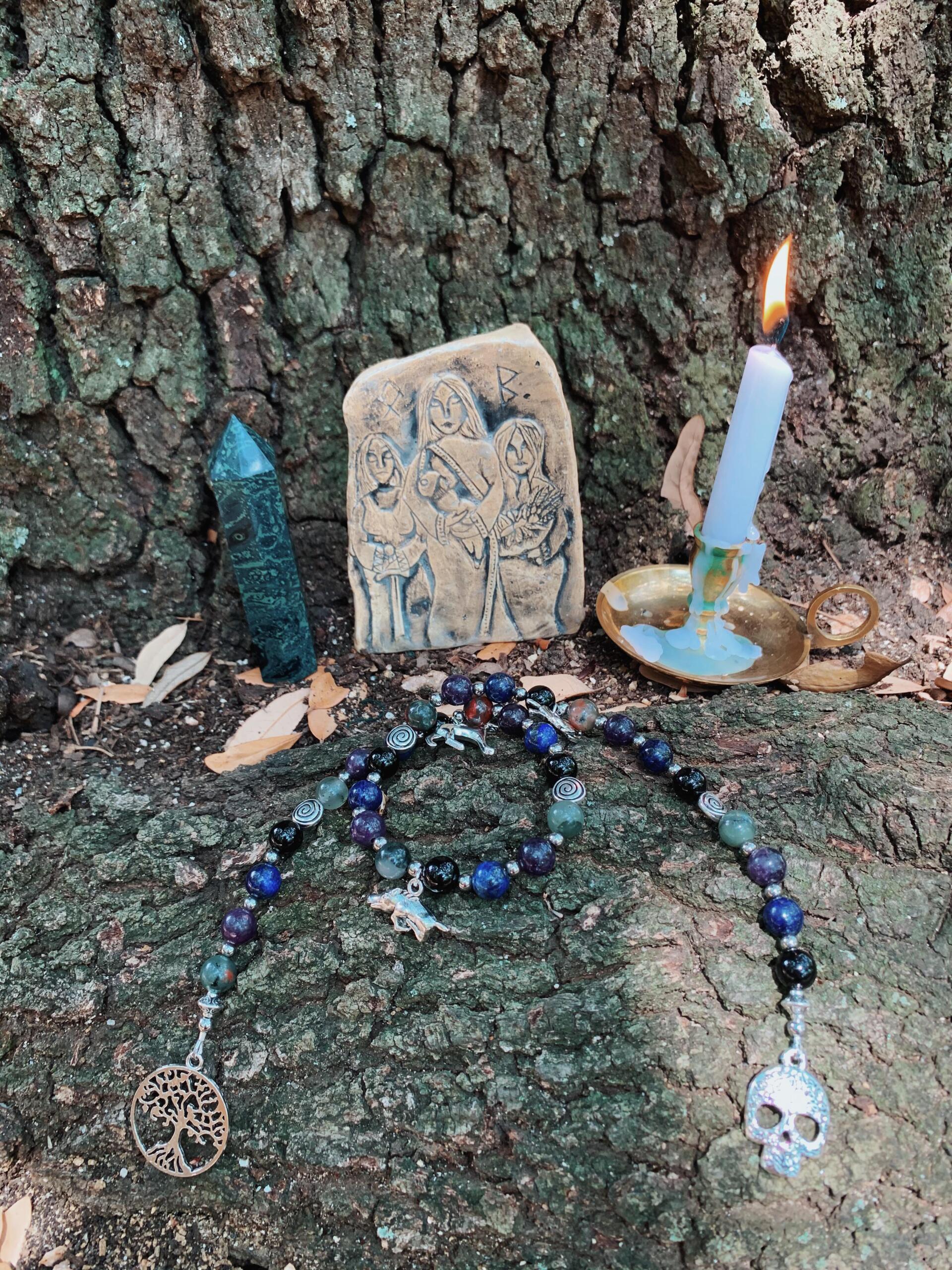 A candle is lit in a candle holder on a tree trunk.