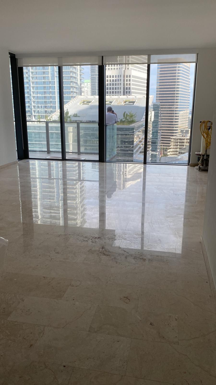 A large empty room with a lot of windows and a balcony.