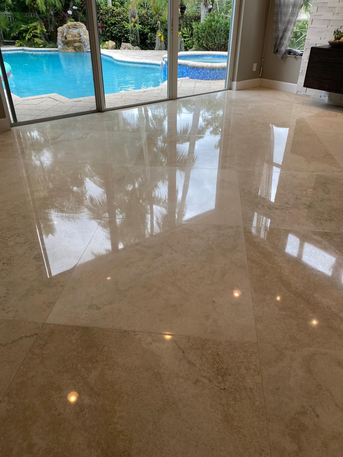 A marble floor in a living room with a swimming pool in the background.
