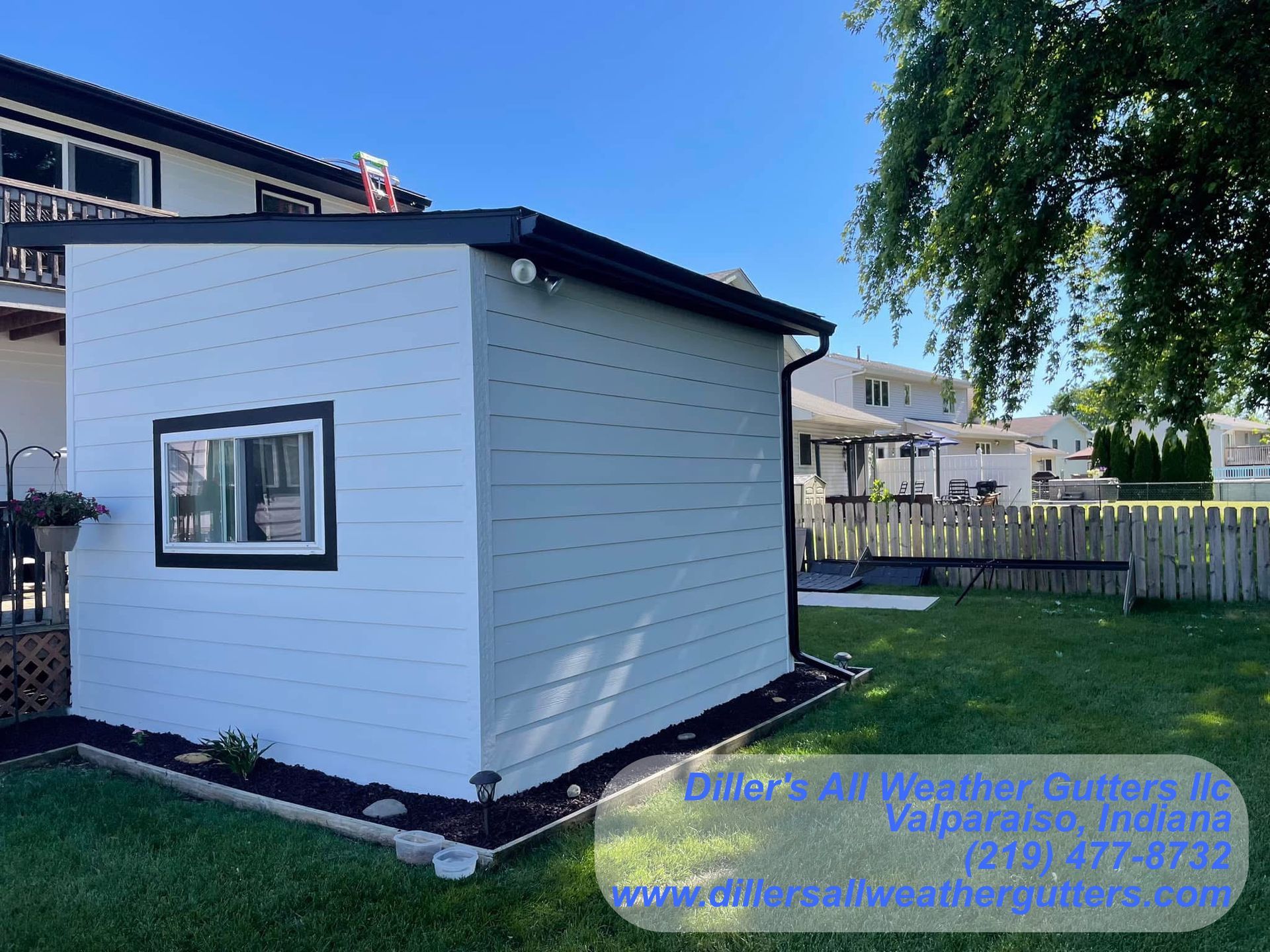A white shed with a window on the side of it. Gutter installation in Northwestern Indiana