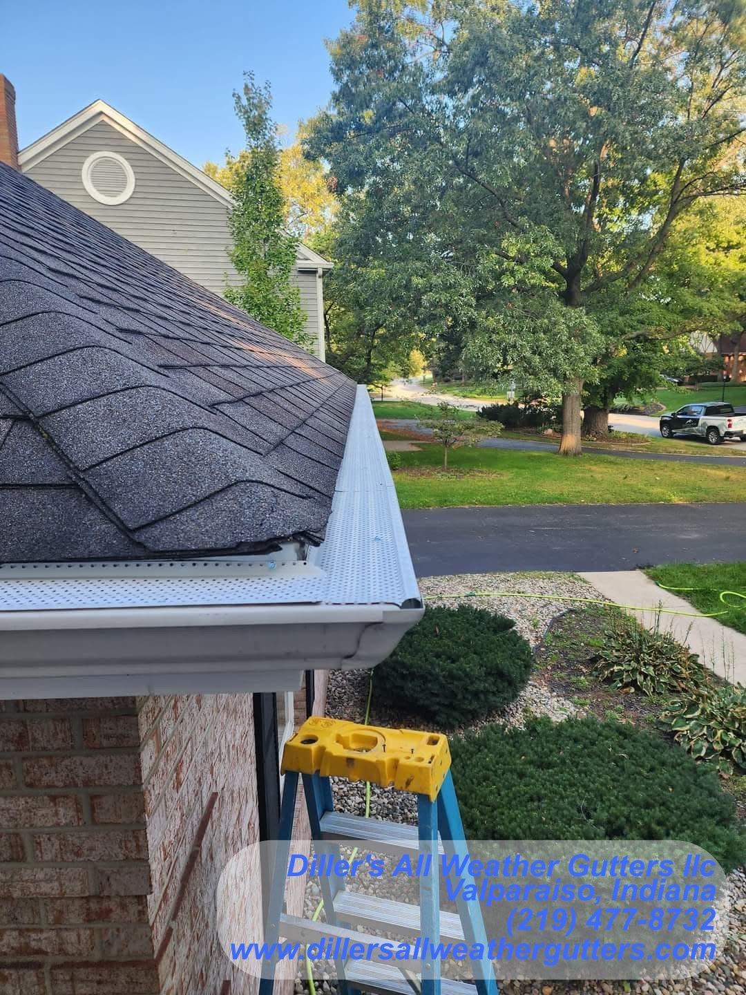 A ladder is sitting on the side of a house next to a gutter.