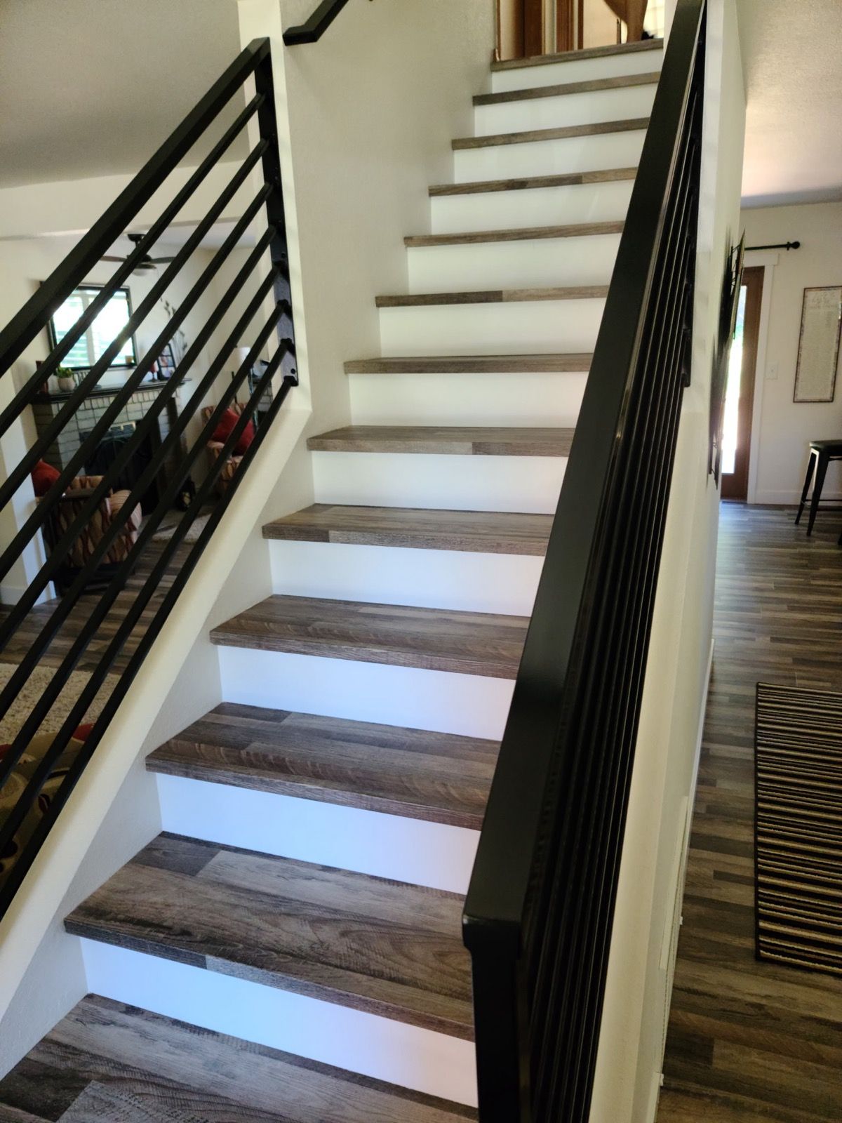 A set of stairs with a black railing in a house