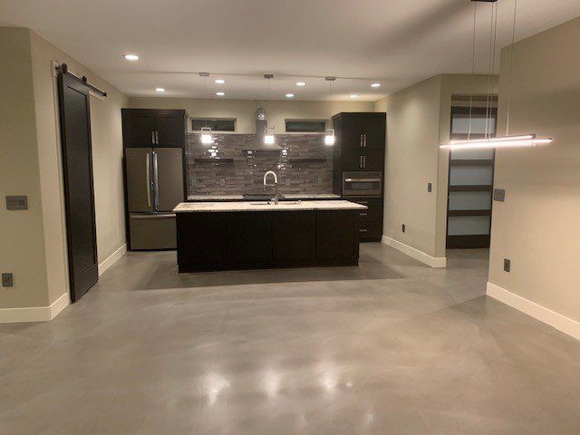 An empty kitchen with a large island in the middle