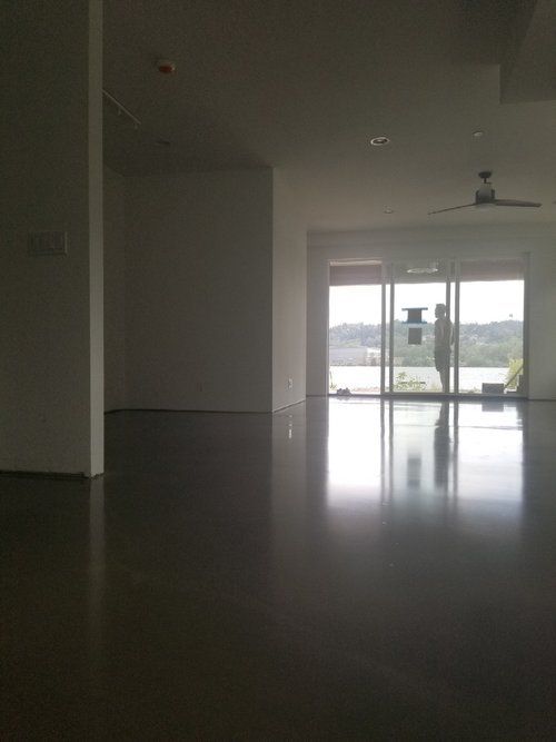 An empty room with a ceiling fan and a large window.