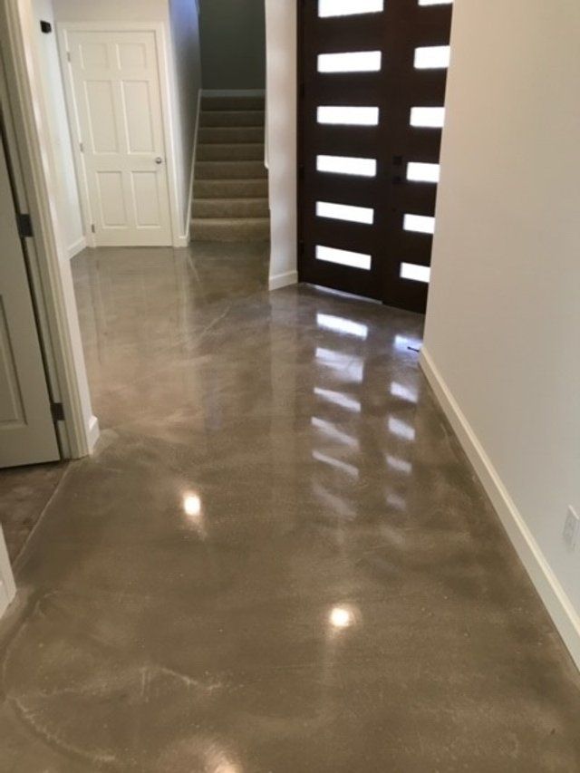 A hallway with a shiny concrete floor and stairs.