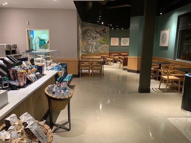 The inside of a starbucks coffee shop with tables and chairs.
