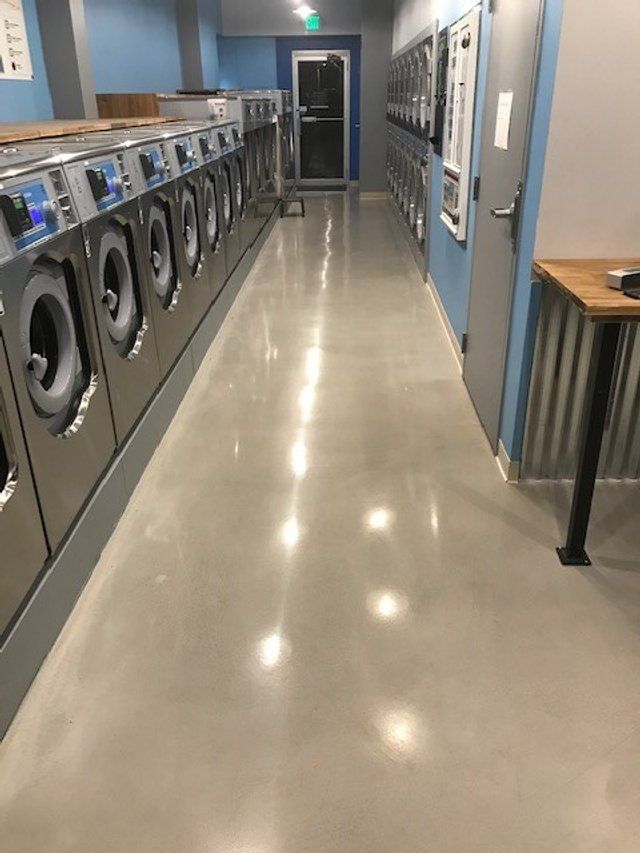 A laundromat with a long hallway filled with washing machines.