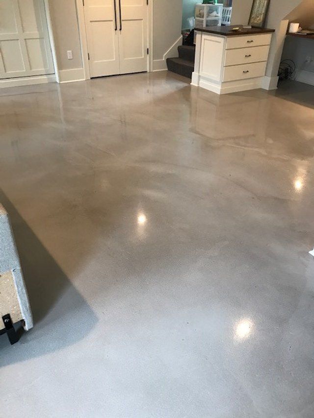 A living room with a concrete floor and stairs.