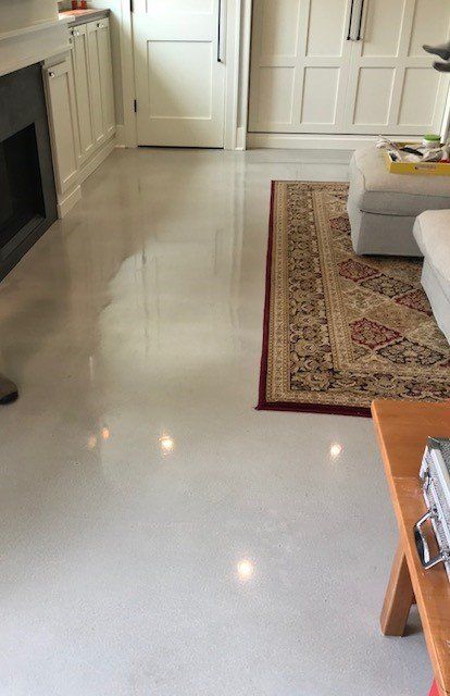A living room with a rug on the floor and a fireplace.