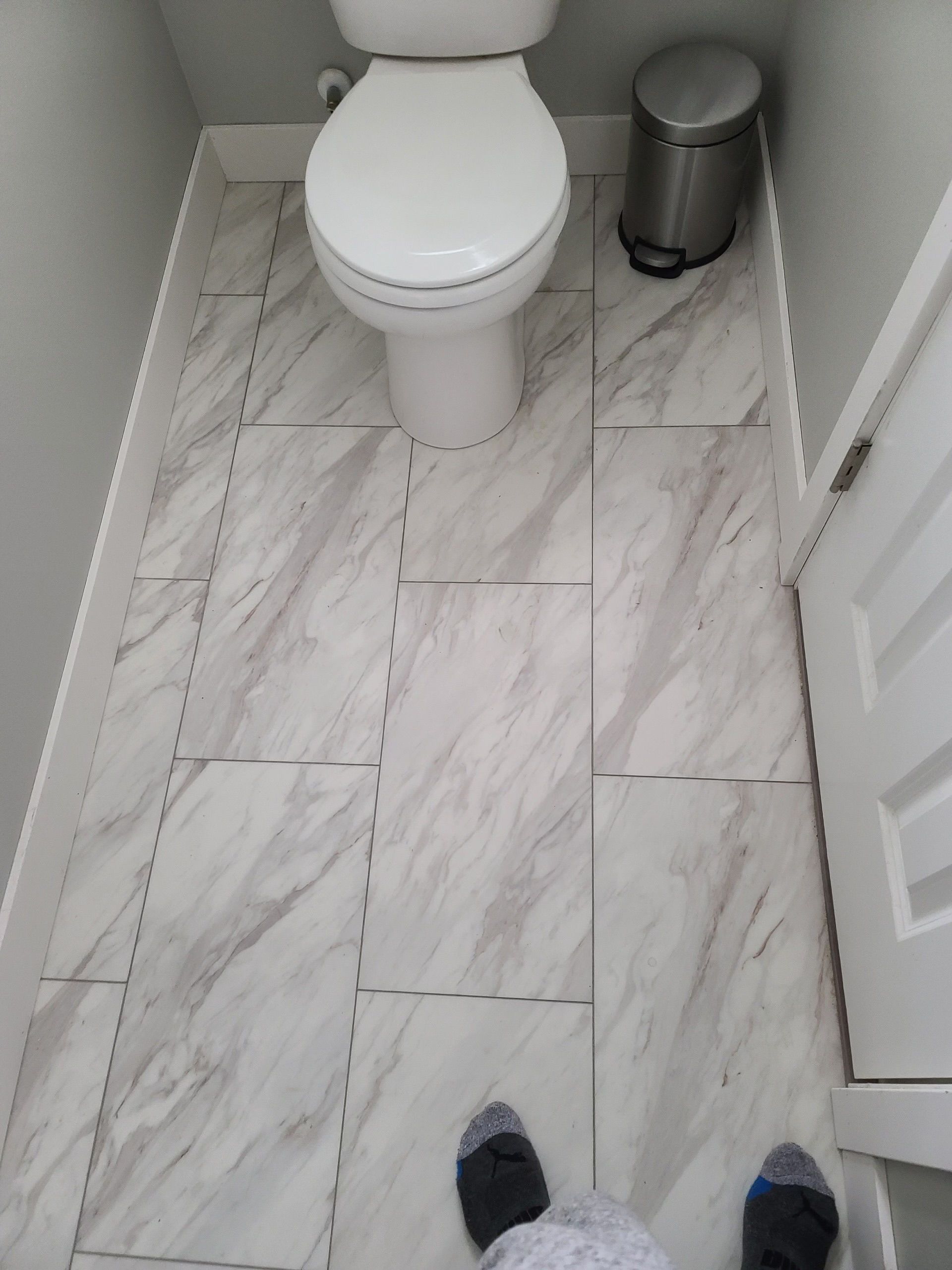 A person standing next to a toilet in a bathroom