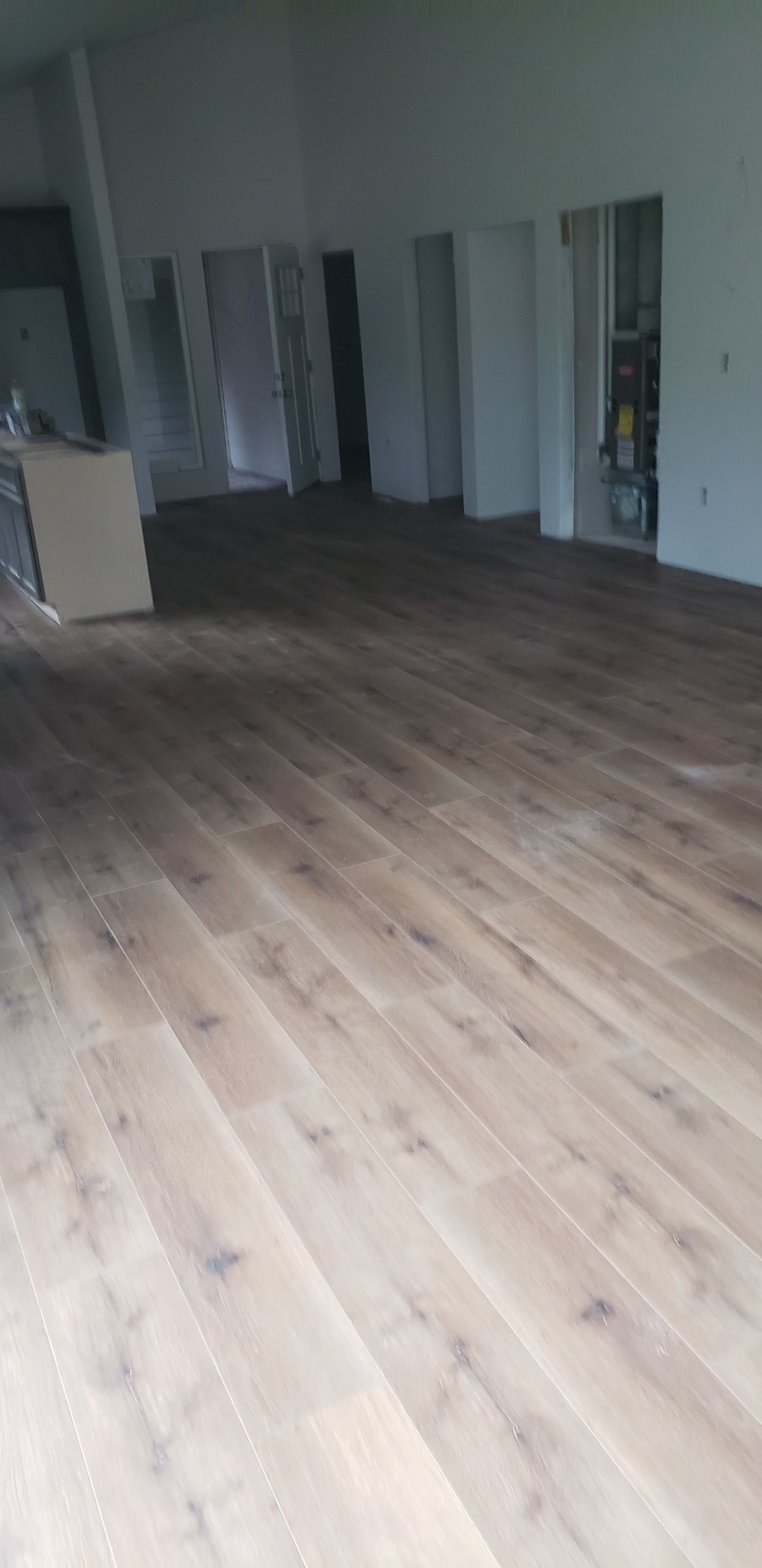 A large room with a wooden floor and white walls.