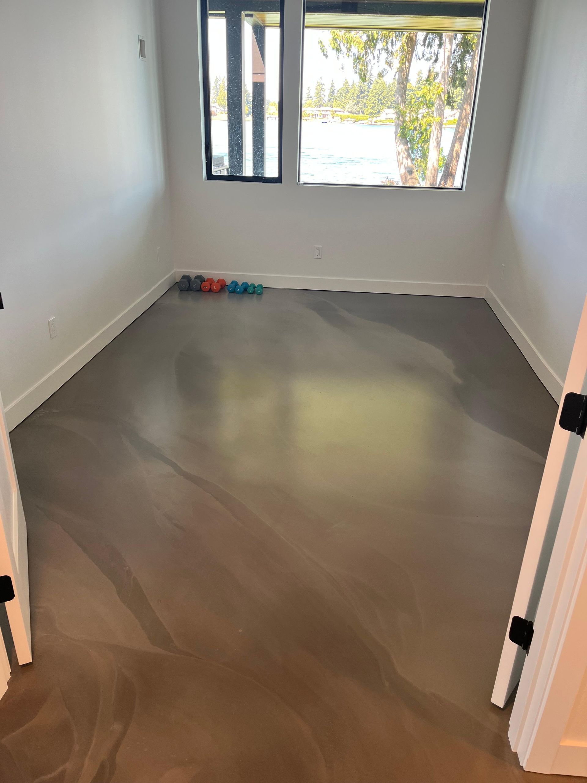 An empty room with a concrete floor and a window.