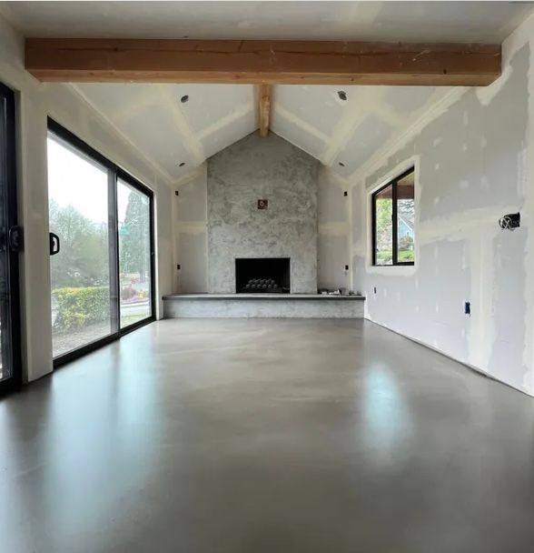 An empty living room with a fireplace and sliding glass doors.