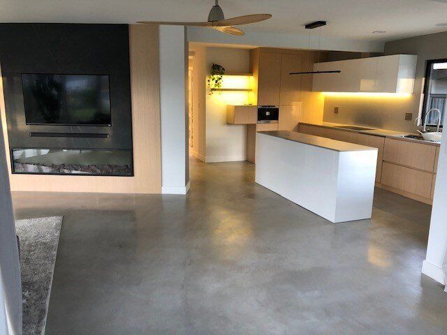 A living room and kitchen with a ceiling fan