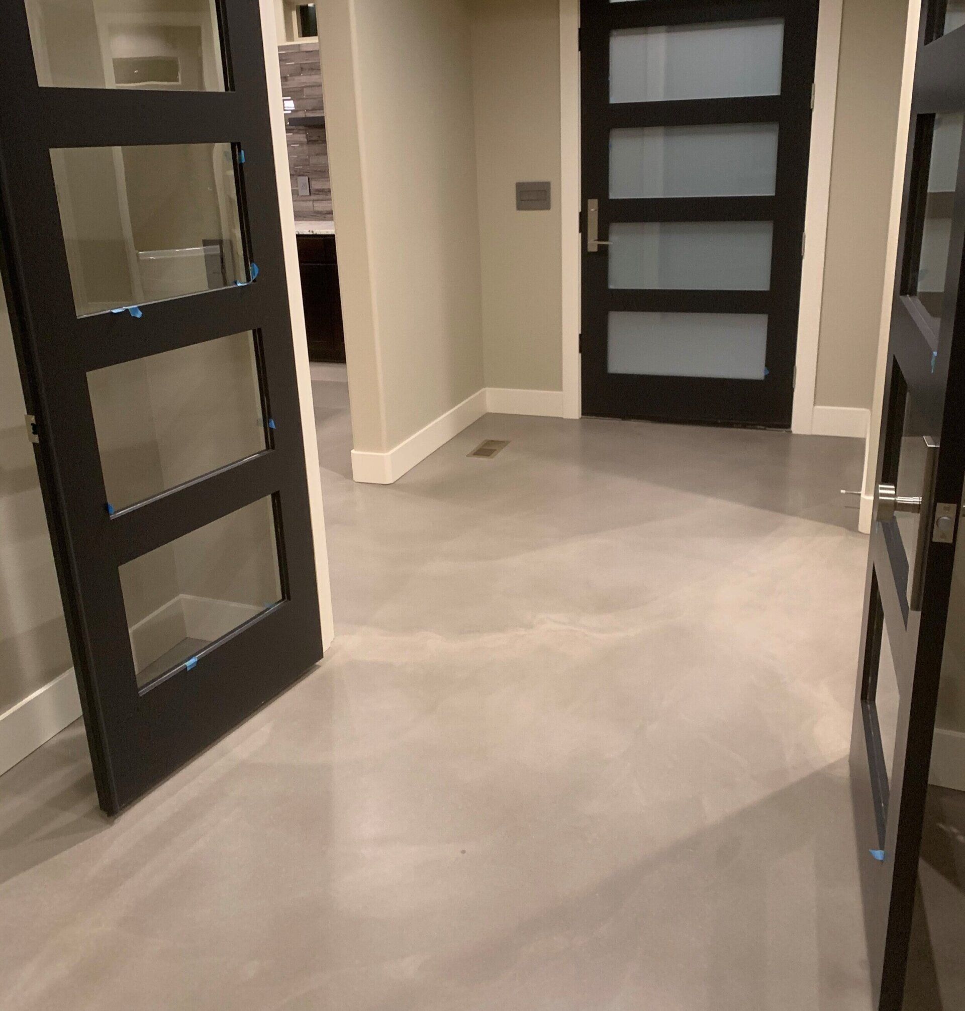 A hallway with black doors and a gray floor