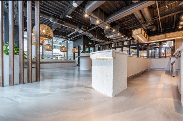 A large room with a lot of windows and a concrete floor.