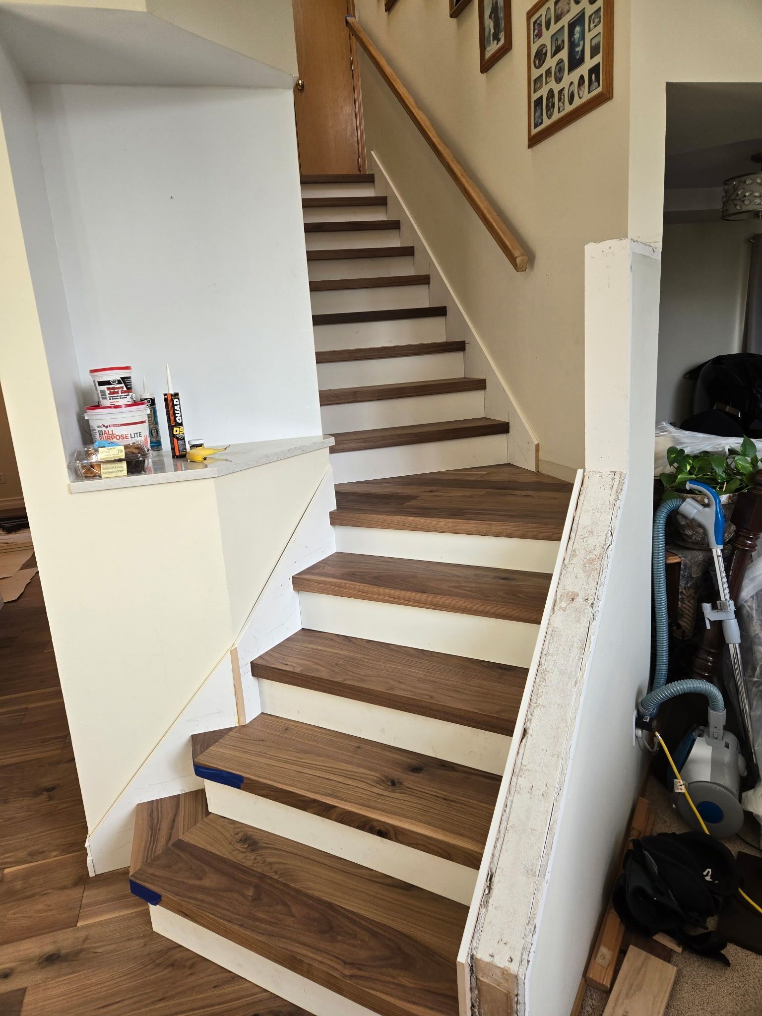 A wooden staircase with a white railing in a house.