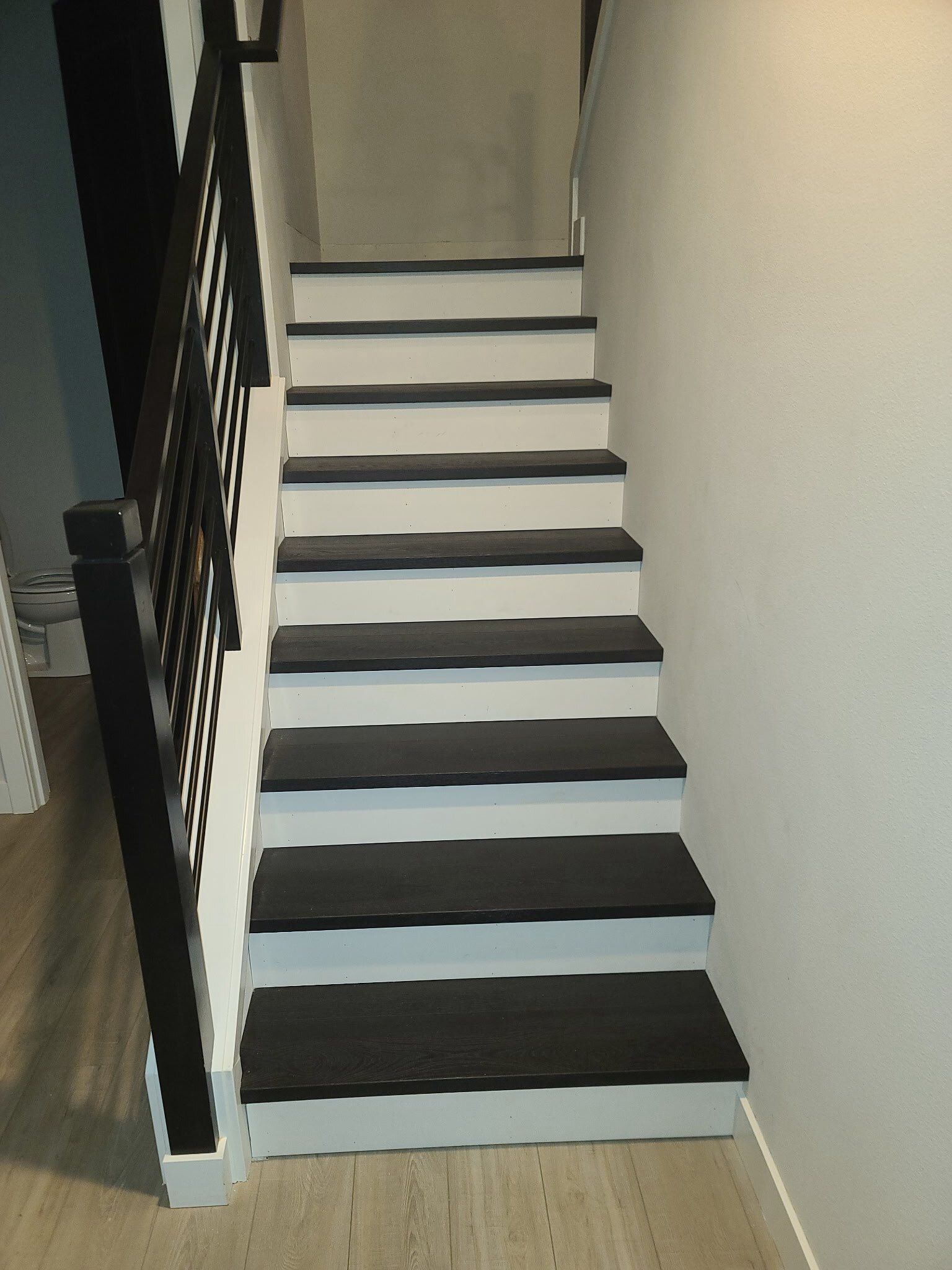 A black and white staircase with a black railing