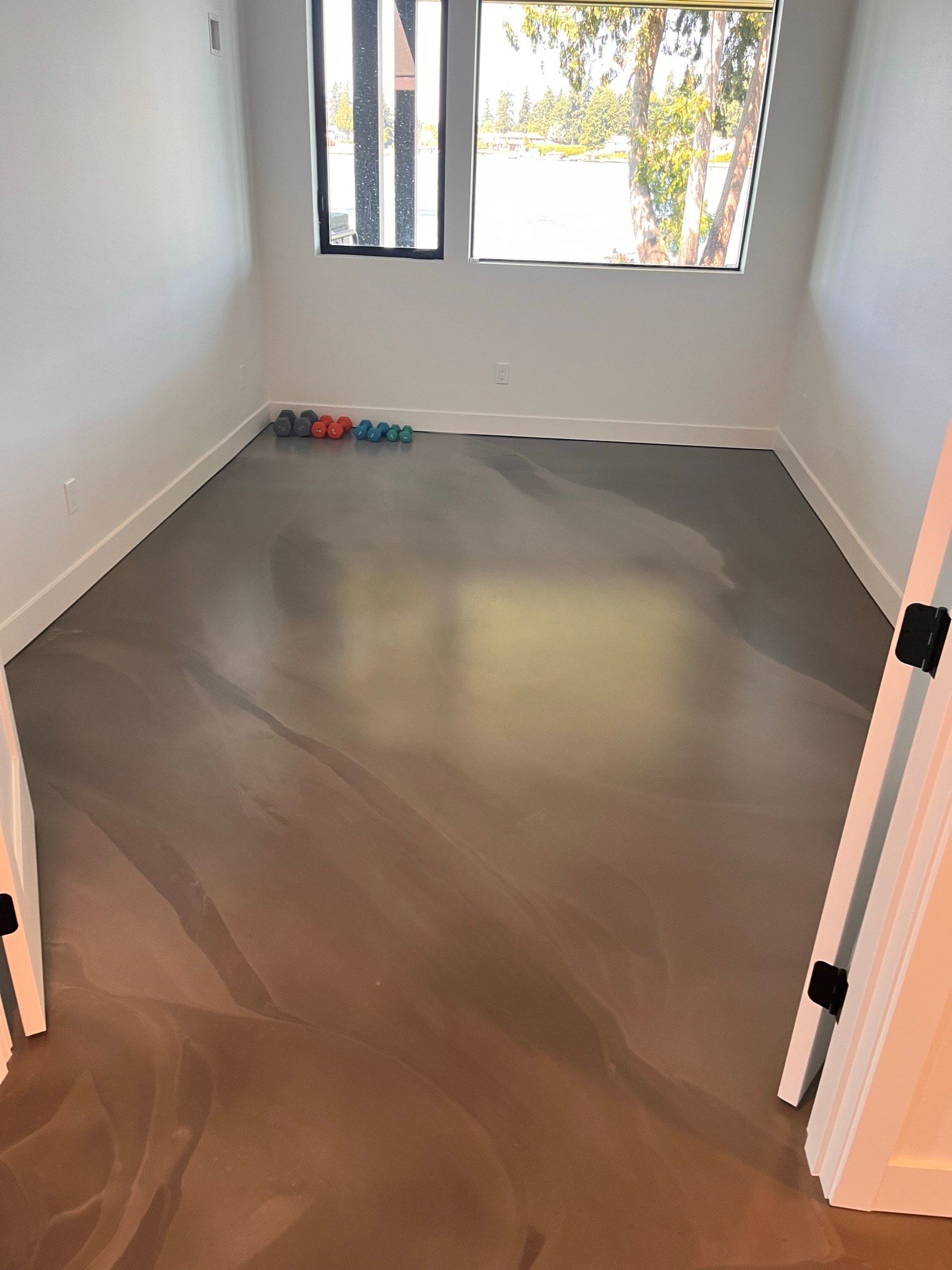 An empty room with a concrete floor and a window.