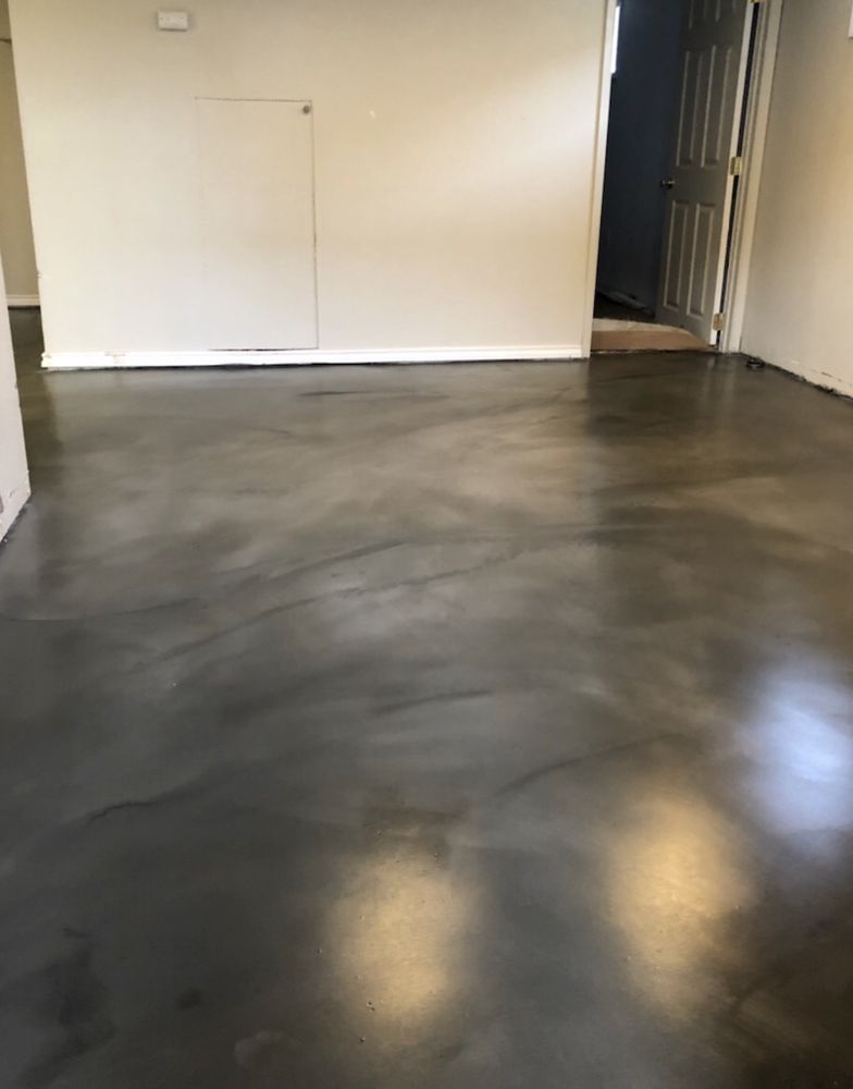 A living room with a concrete floor and a door.