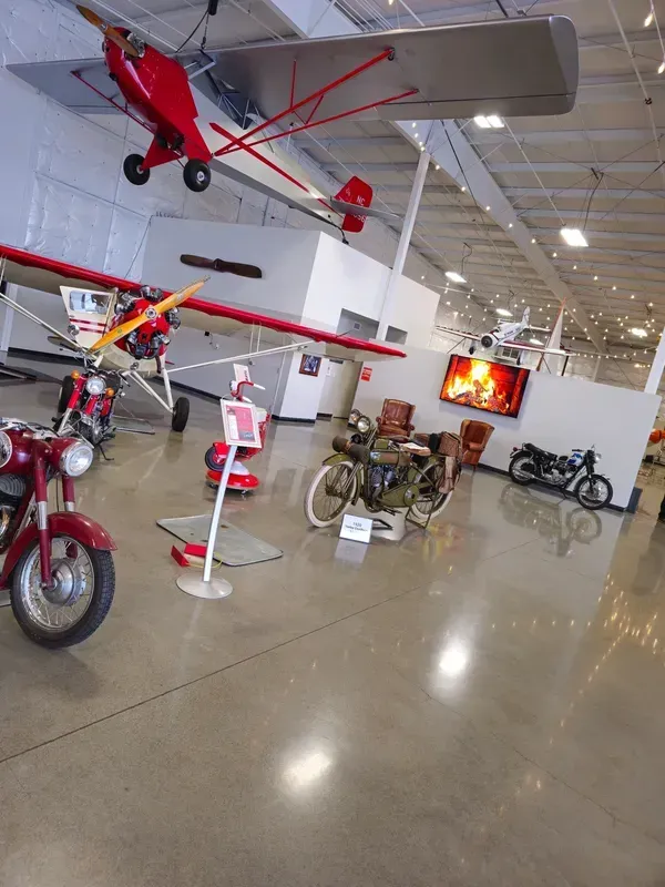 A plane is hanging from the ceiling in a museum