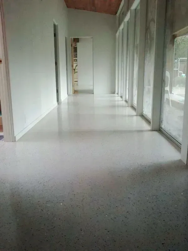 A long hallway with a lot of windows and a white floor.