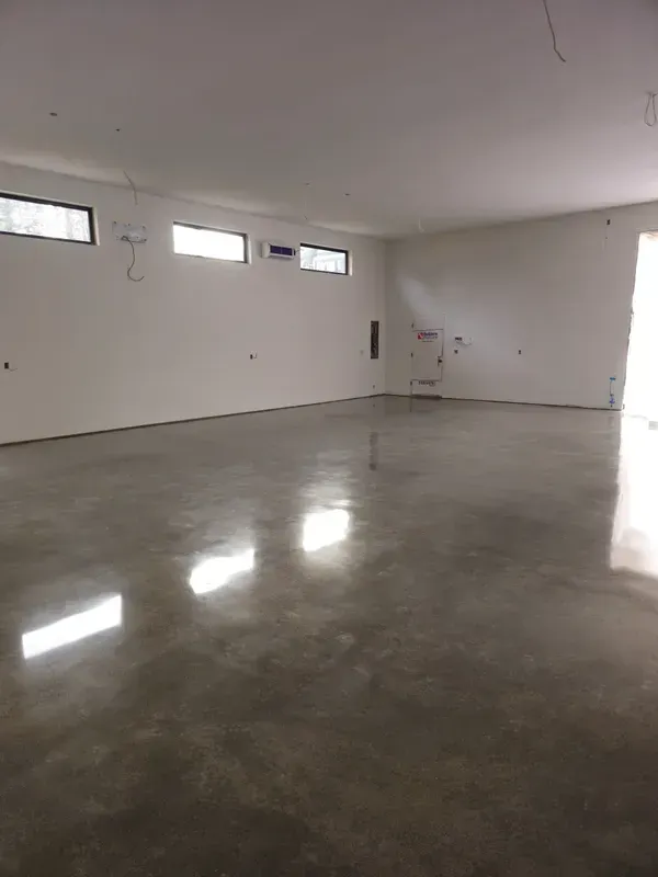 A large empty room with a shiny concrete floor and white walls