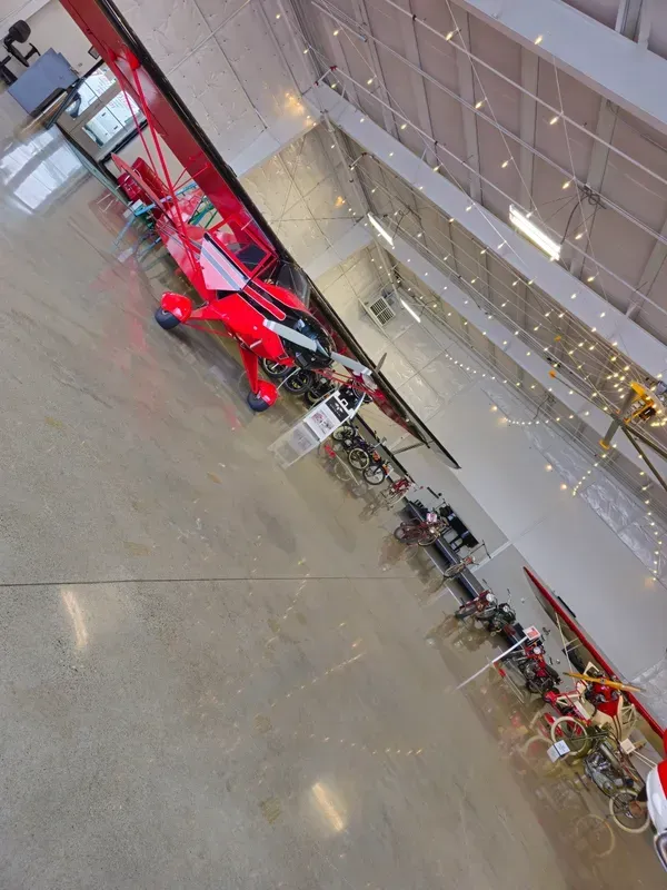 A red plane is parked in a large building
