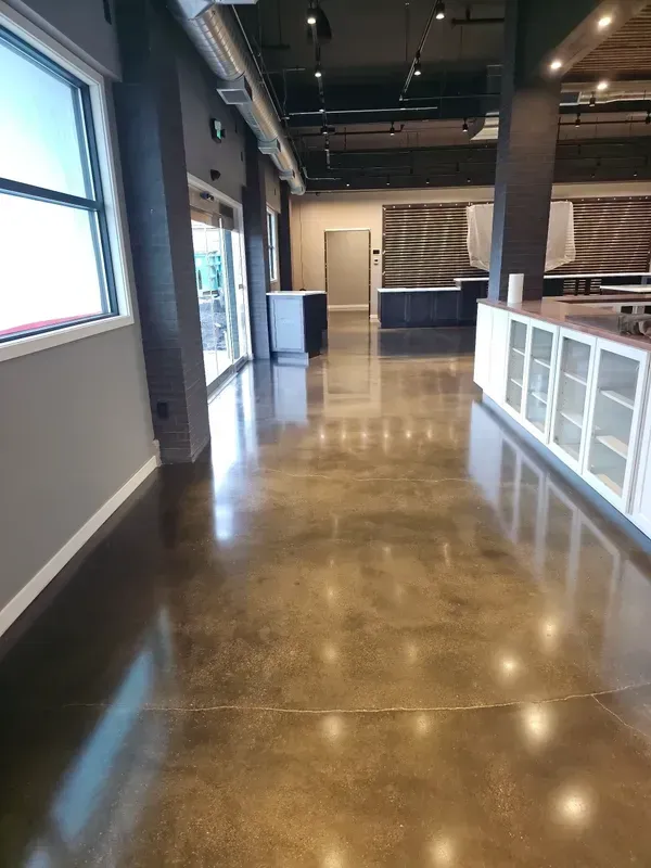A large room with a shiny concrete floor and a lot of windows.