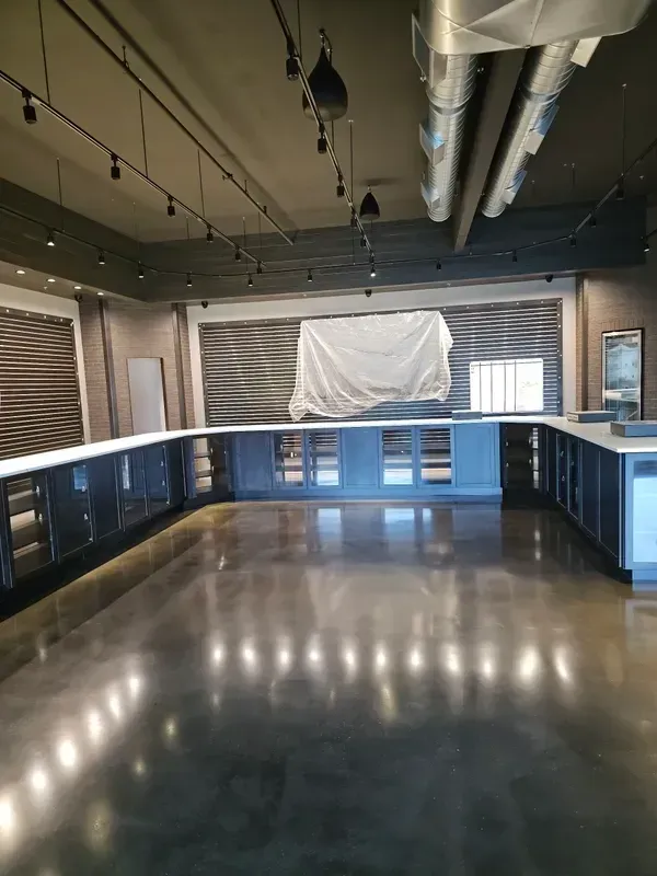 A large empty room with a white tarp on the wall