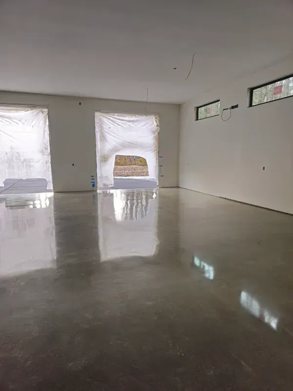 A large empty room with a shiny concrete floor and white walls.