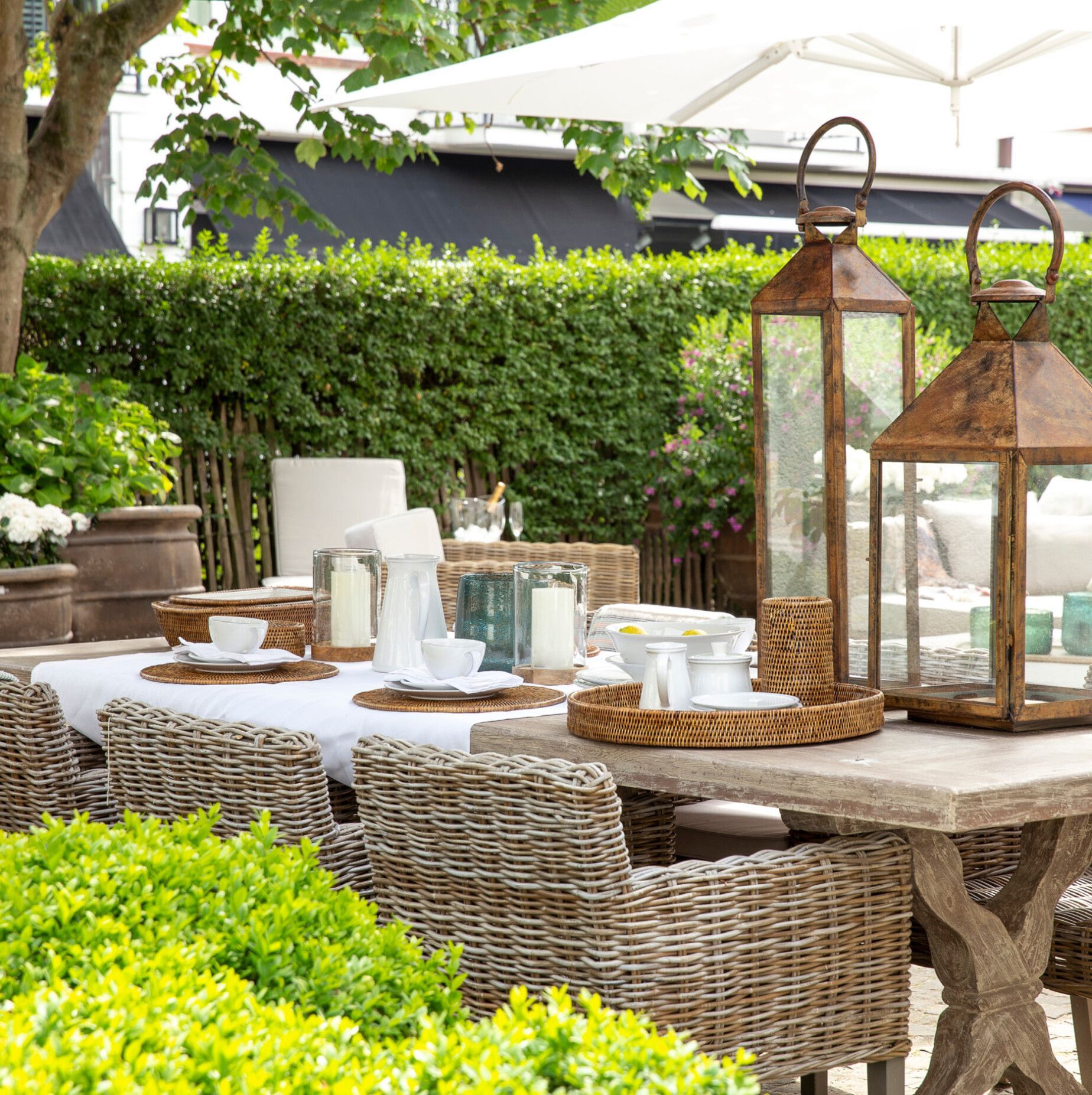 A table with wicker chairs and lanterns on it