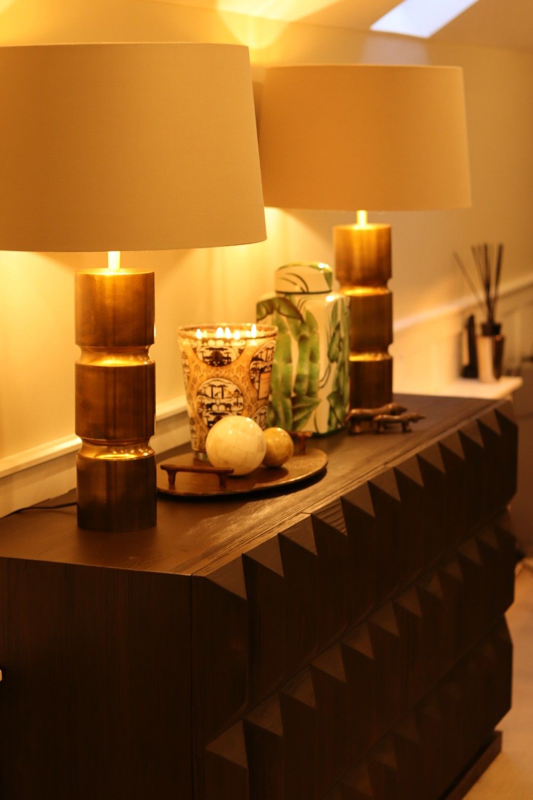 A table with two lamps and a candle on it