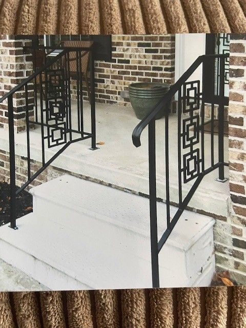 Front steps with black metal railings and a ramp leading to a brick house porch