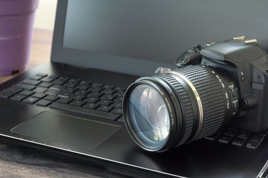 fotocamera nera appoggiata su un computer
