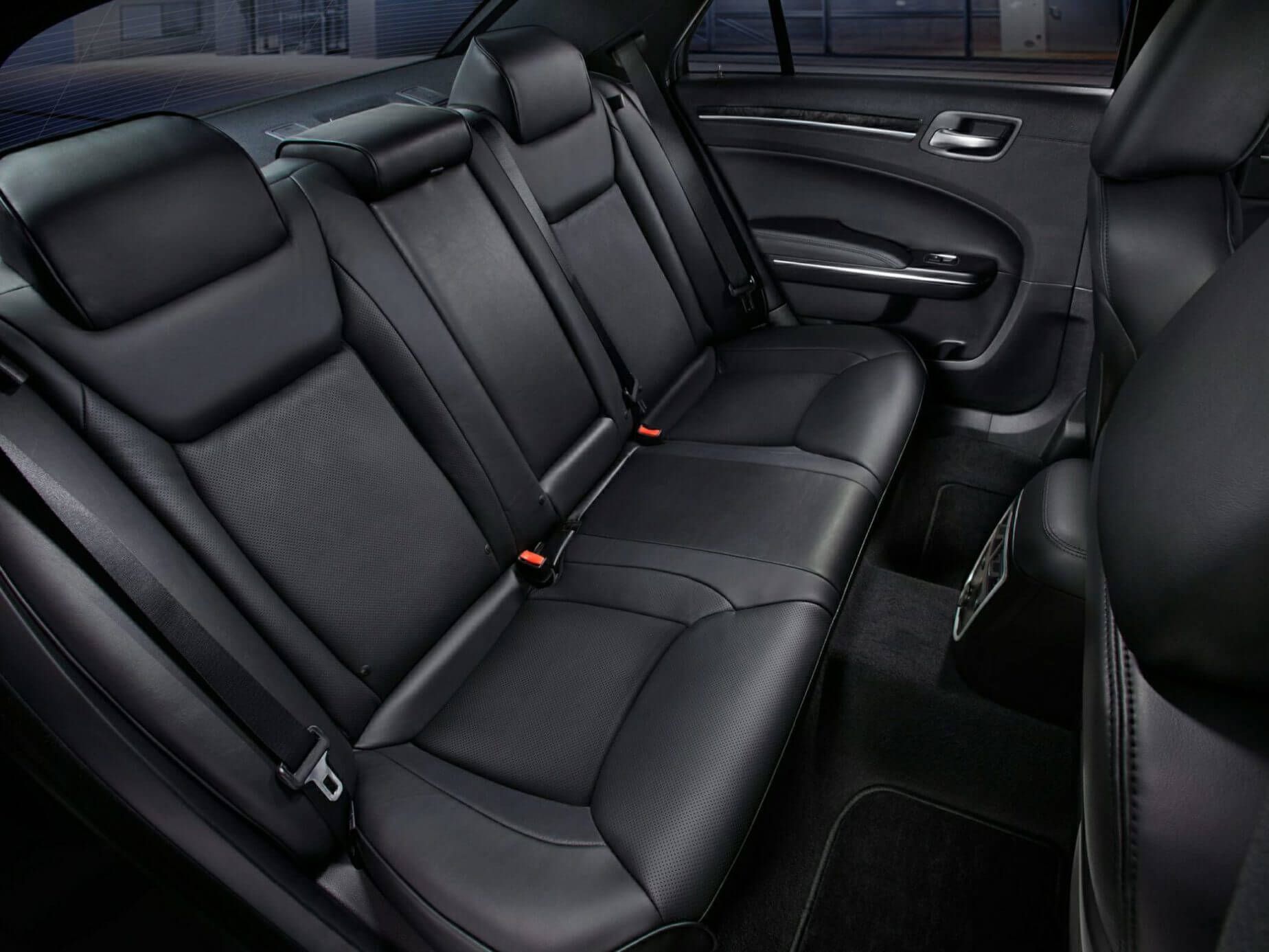 Black leather back seats inside a Chrysler 300 sedan. Seats are detailed, and the interior is dark.