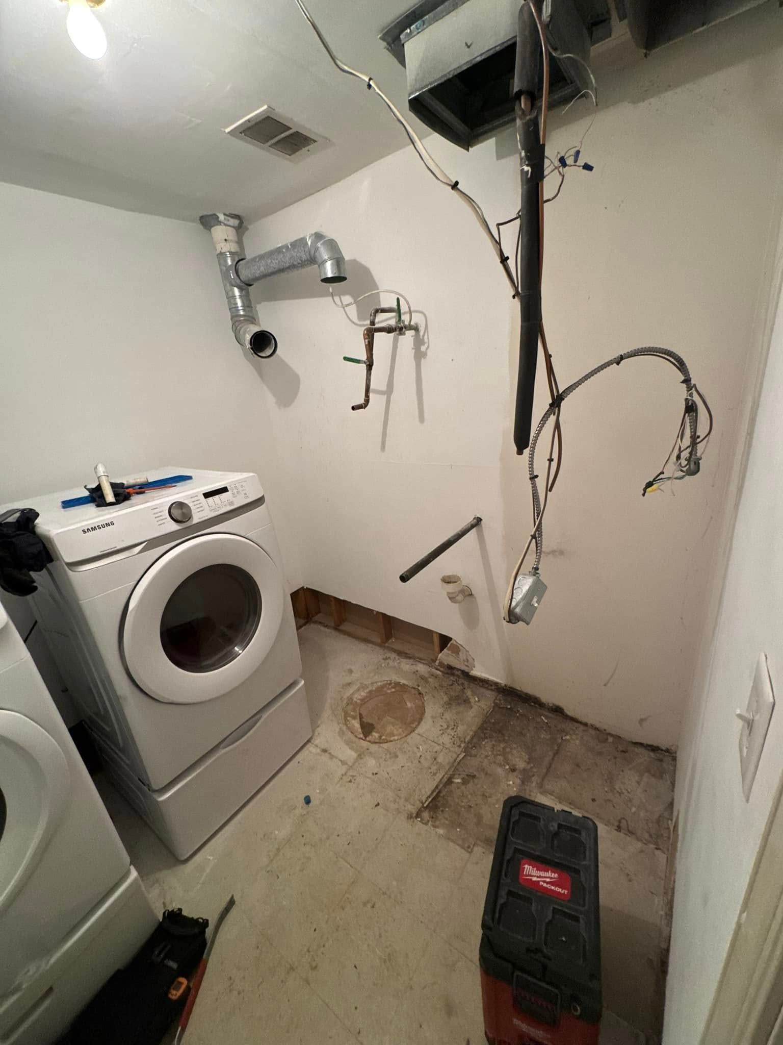 A laundry room with a washer and dryer and a vacuum cleaner.