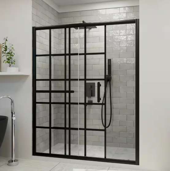 A black-framed, industrial-style sliding glass shower door installed in a bathroom with light grey subway tile walls.