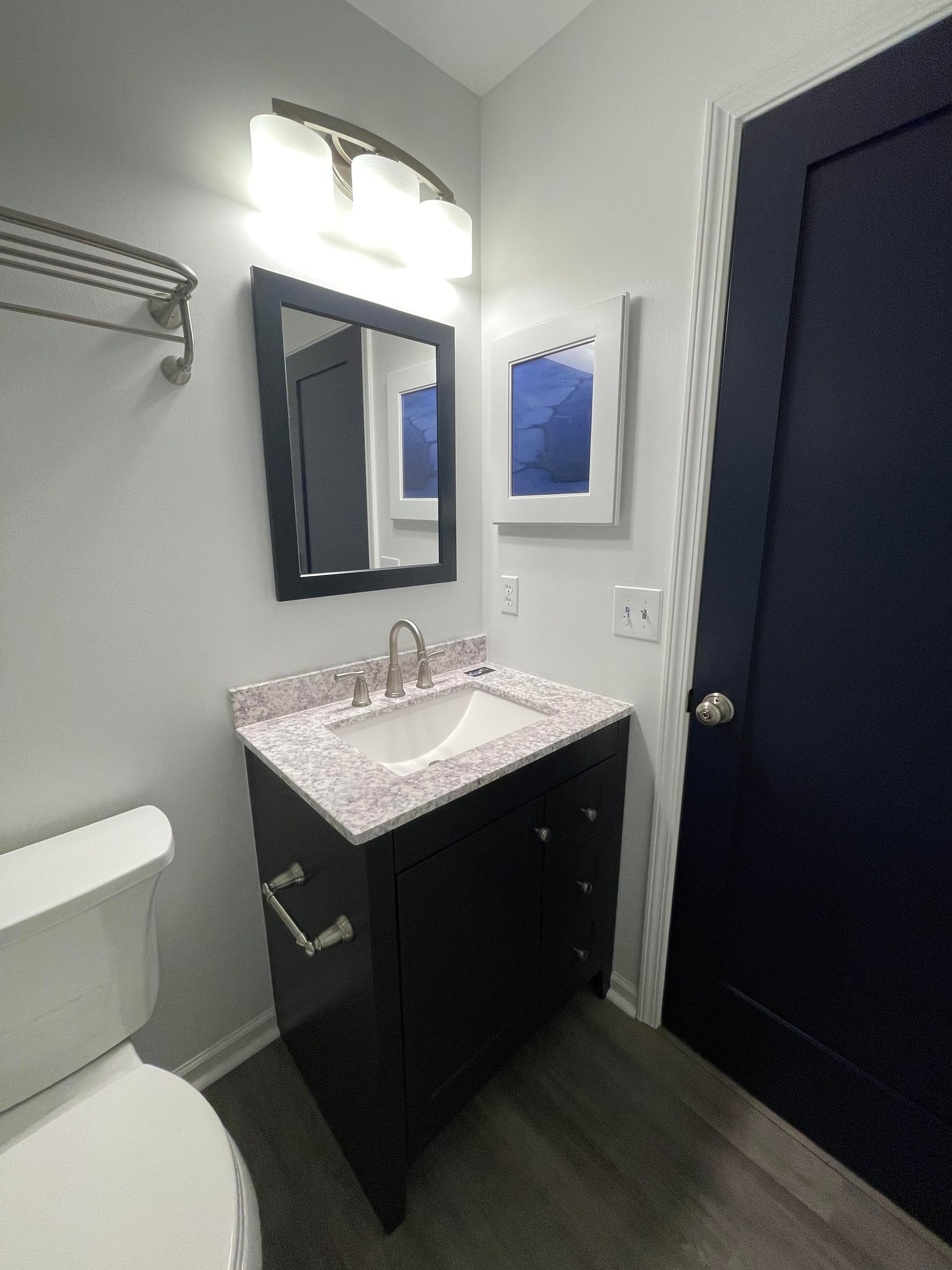 A bathroom with a toilet a sink and a mirror.