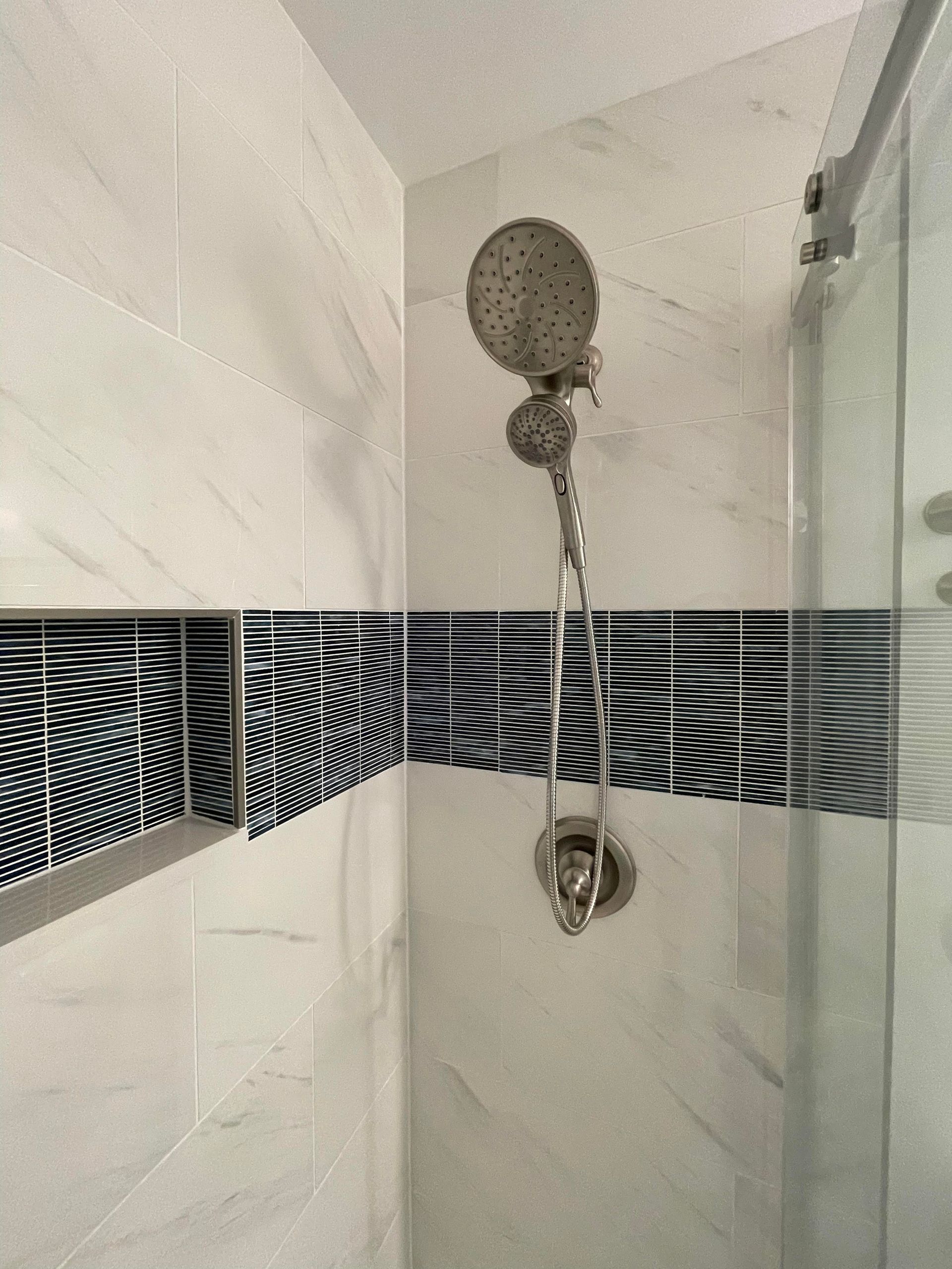 A shower head is hanging from the ceiling in a bathroom.