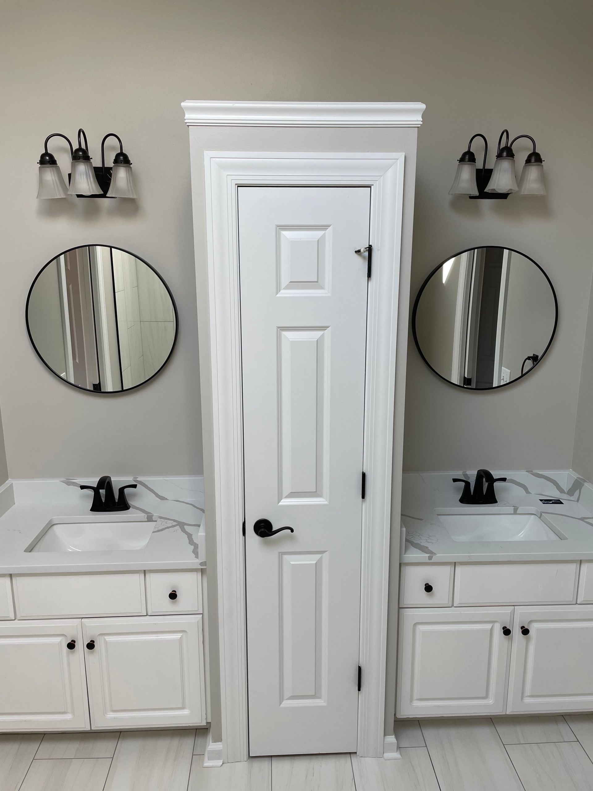 A bathroom with two sinks and two mirrors on the wall
