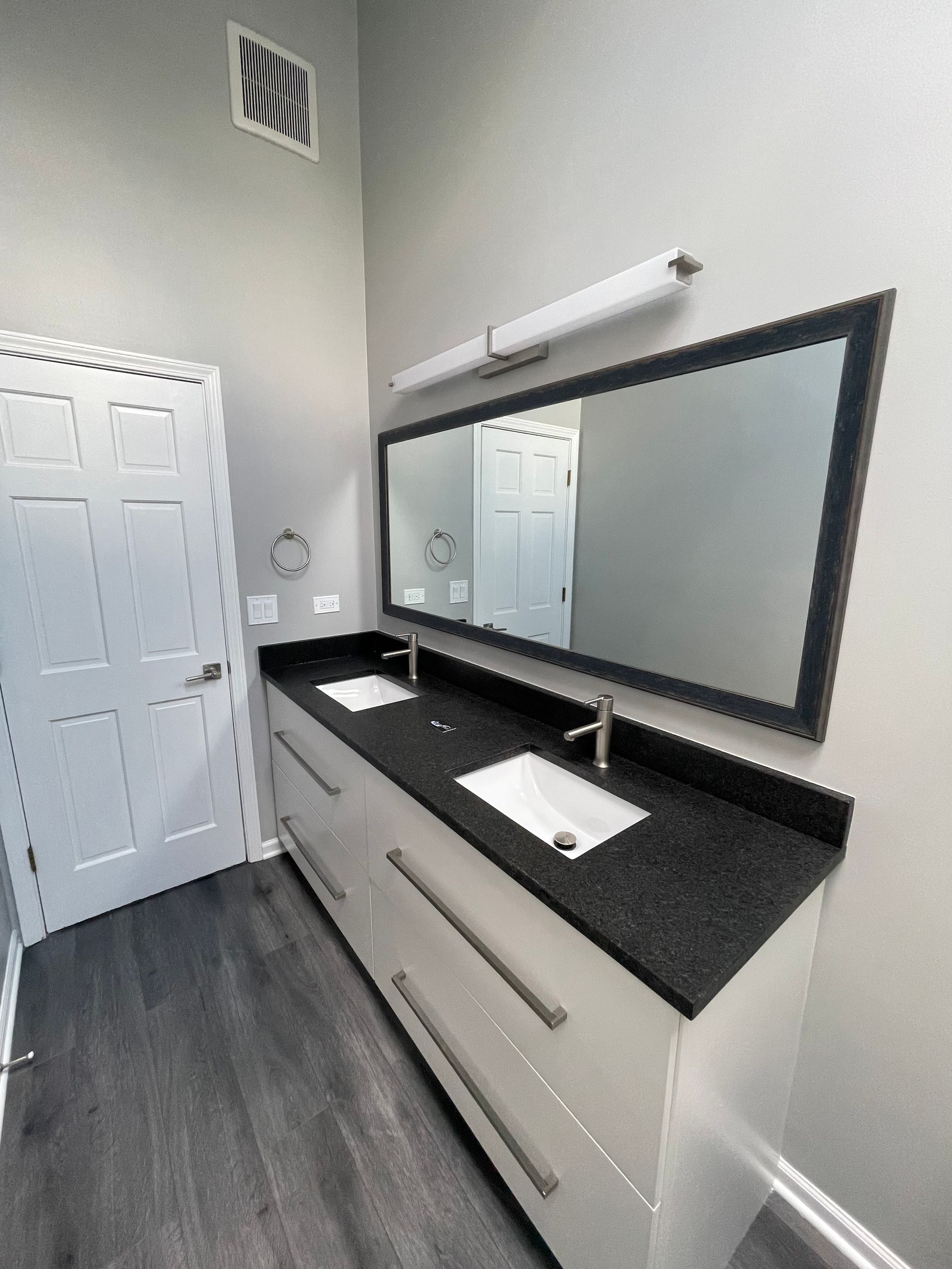 A bathroom with two sinks and a large mirror
