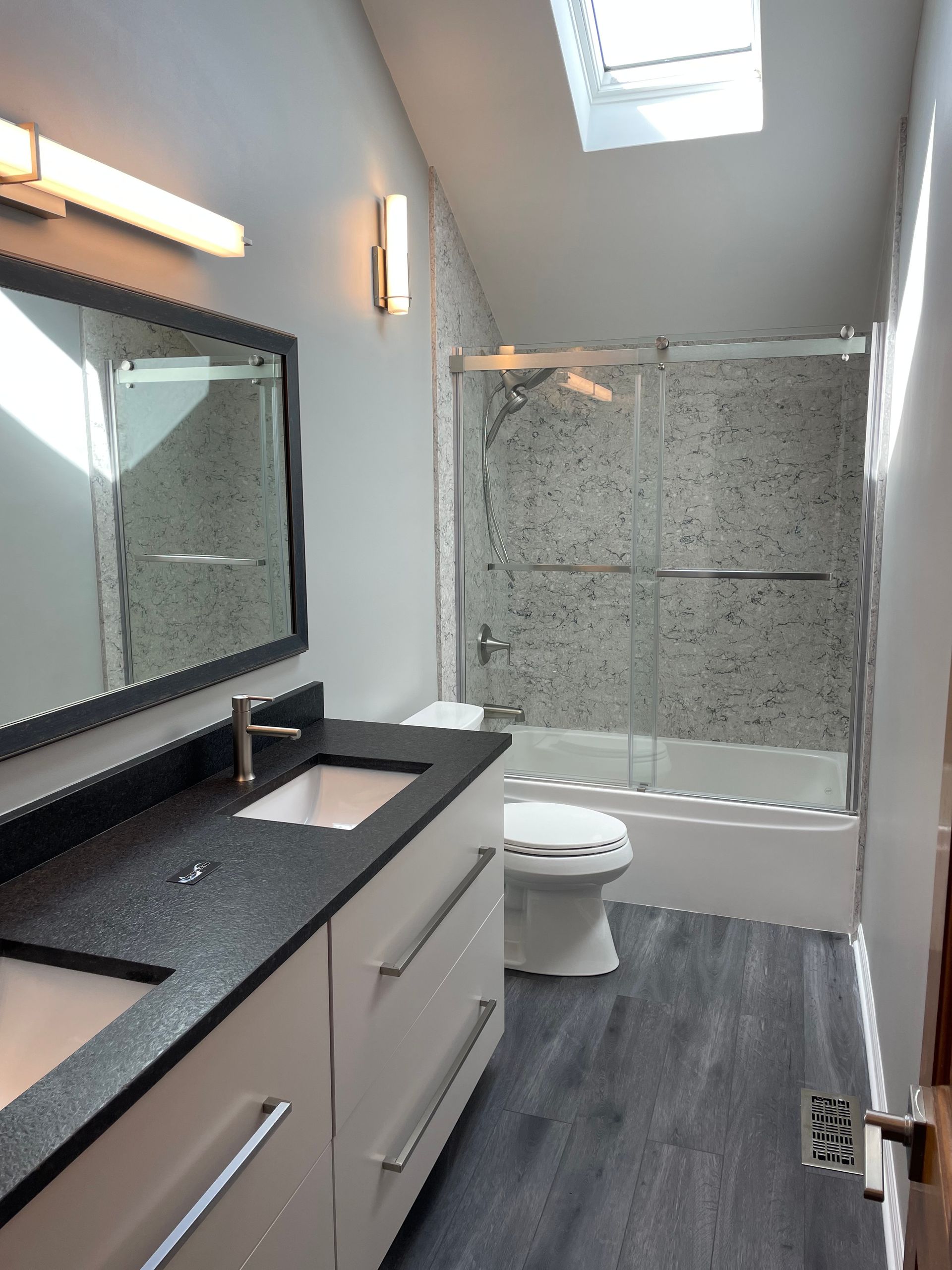 A bathroom with a toilet a sink and a mirror