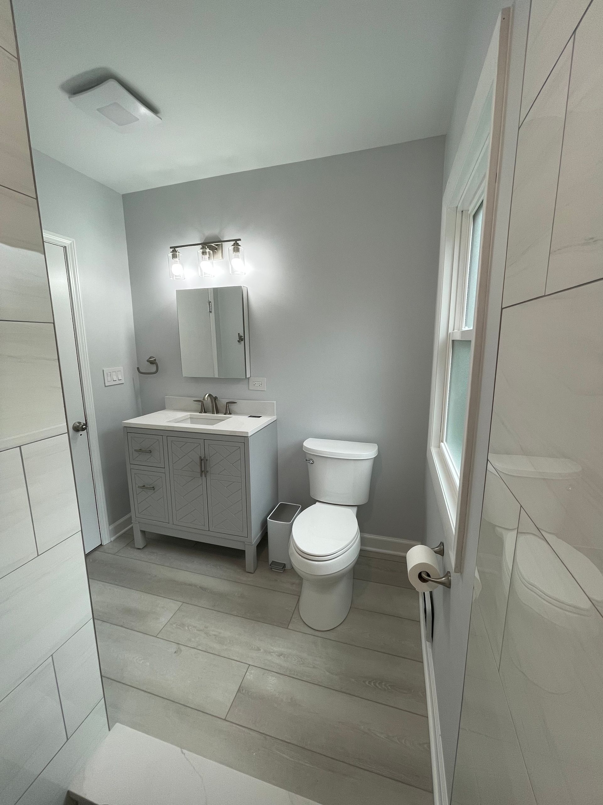 A bathroom with a toilet a sink and a mirror