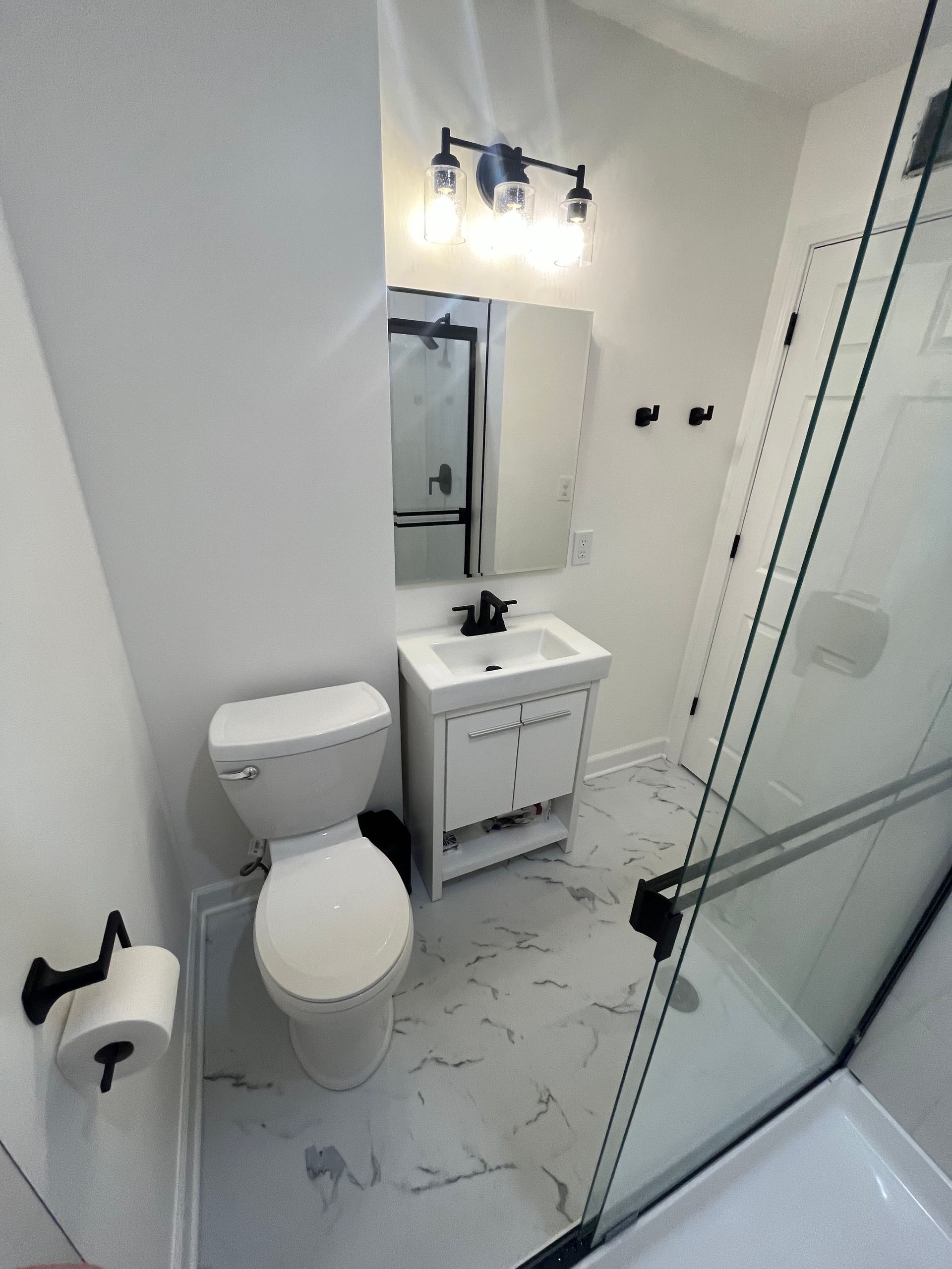 A bathroom with a toilet a sink and a shower