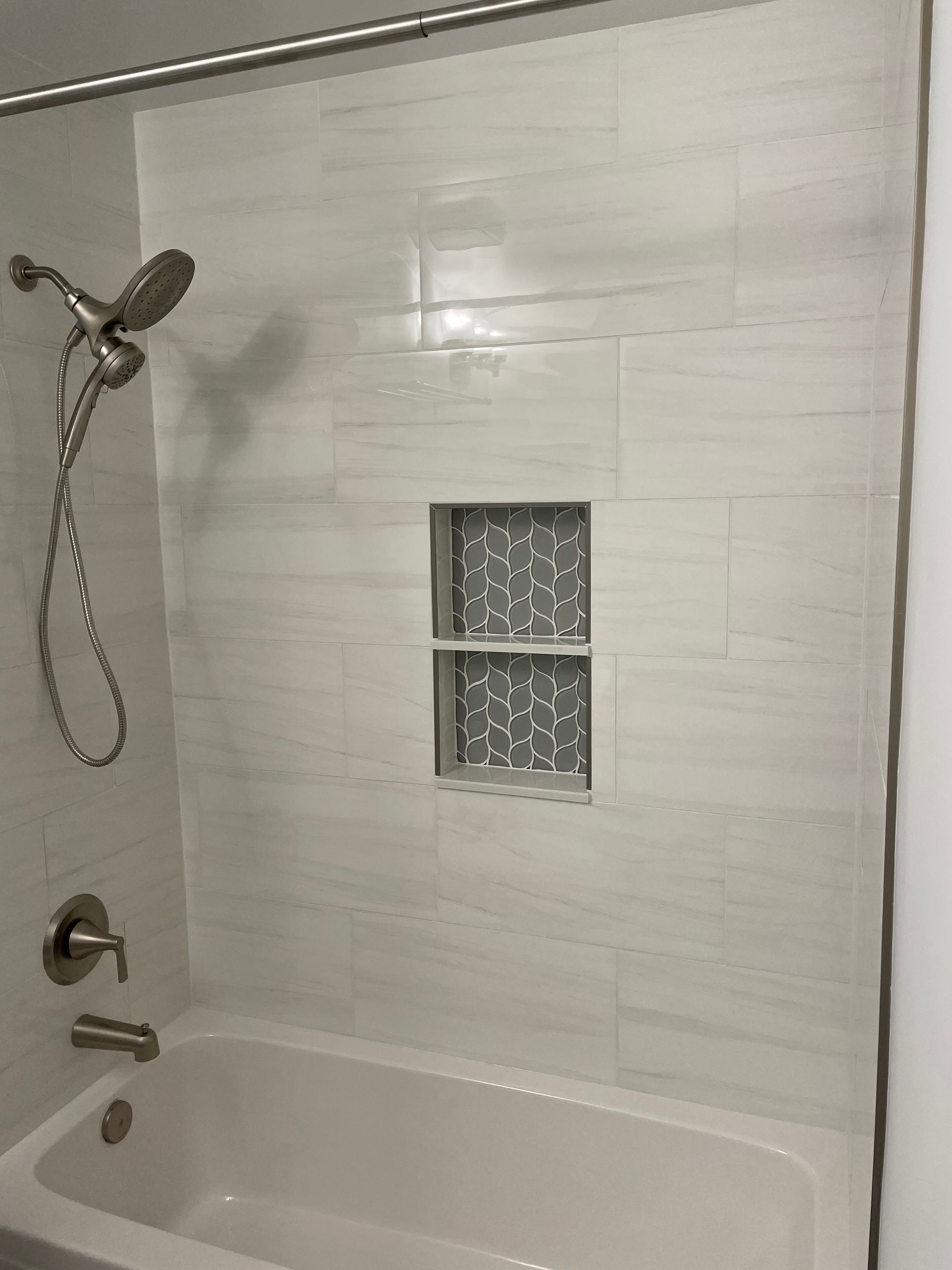 There Is a Bathtub in The Shower with A Shower Head.